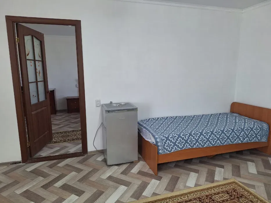 Комната с односпальной кроватью и холодильником