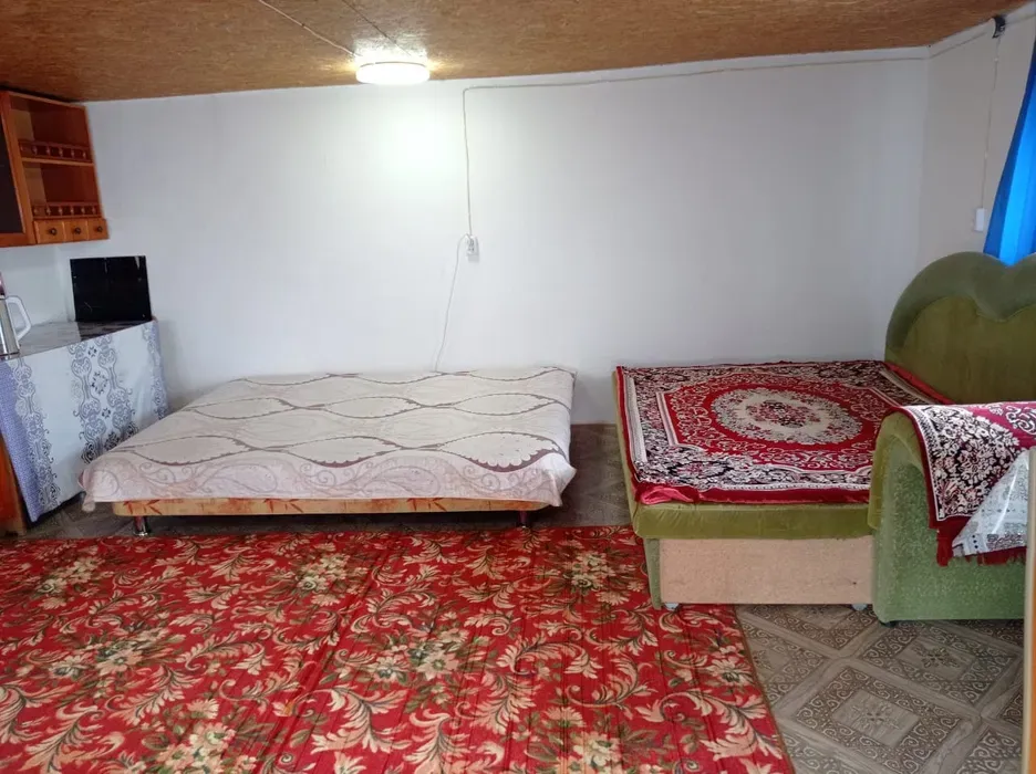 Комната с двуспальной кроватью и зеленым диваном, уютная обстановка