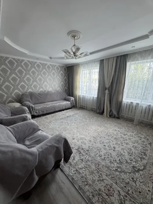 уютная гостиная с мягкой мебелью и светлыми шторами