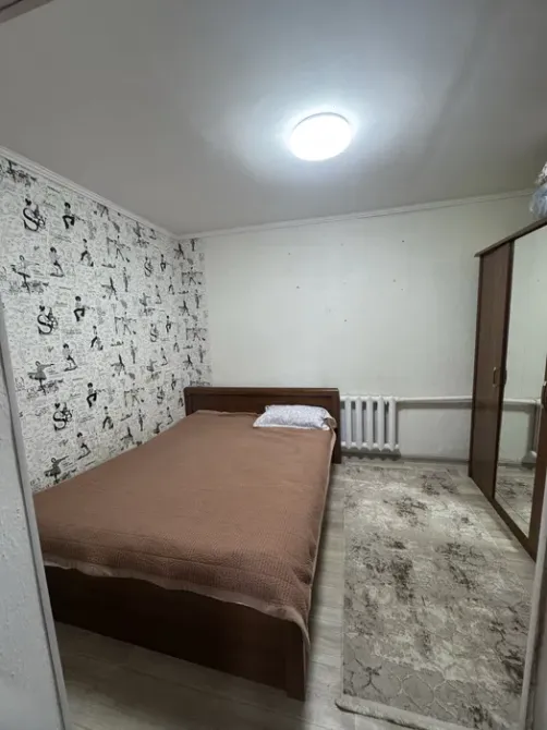 спальня с двухспальной кроватью и шкафом