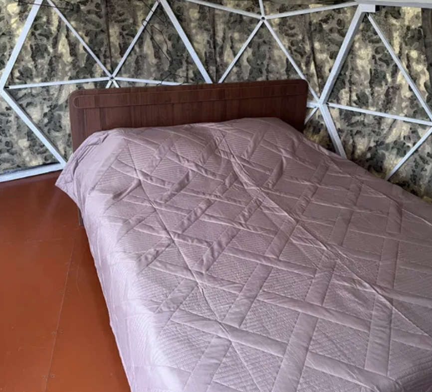 Кровать с постельным бельем в палатке