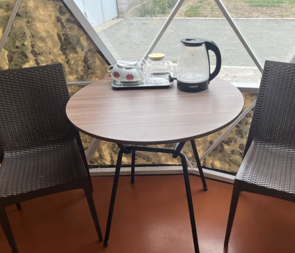 Стол с чайником и посудой в палатке