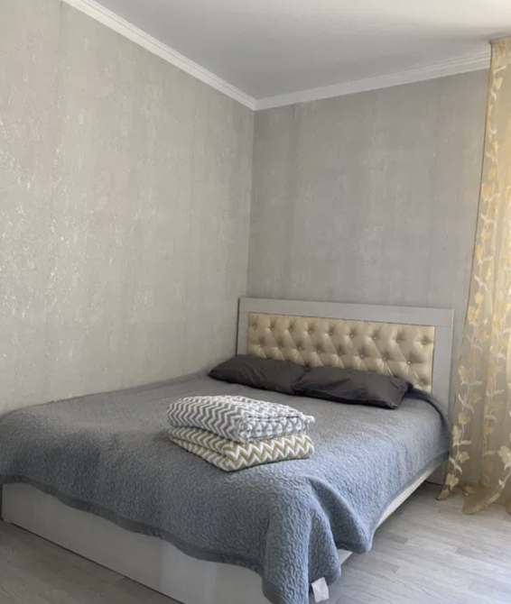 Уютная спальня с односпальной кроватью и светлыми стенами