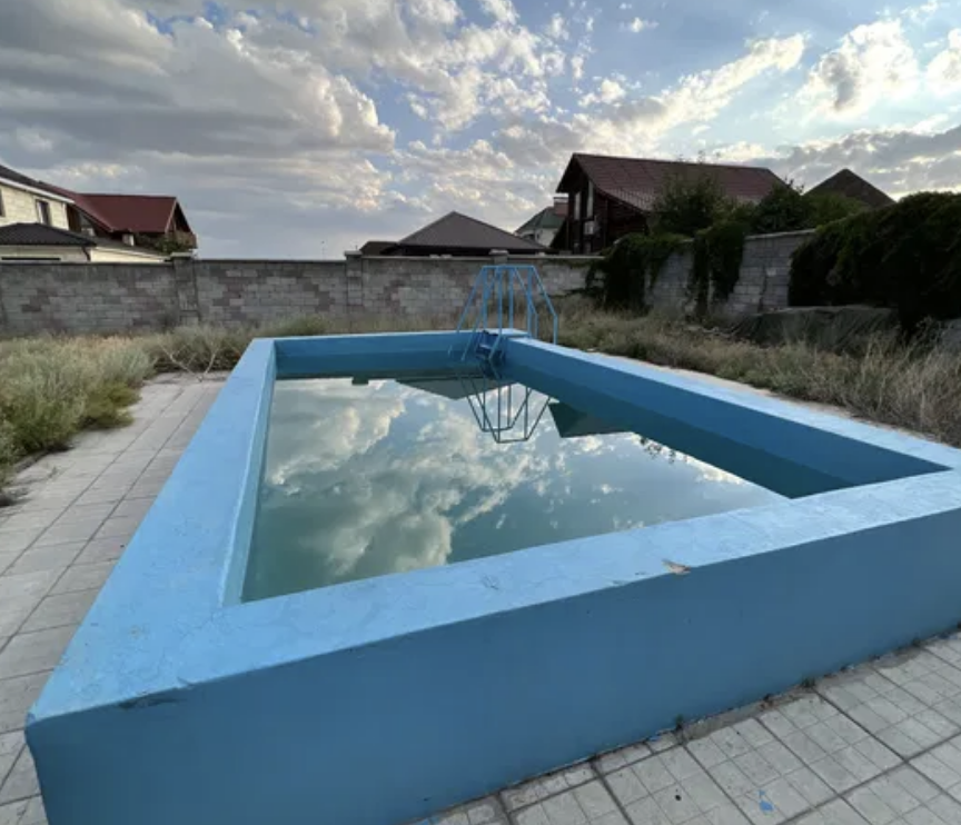 Көгілдір түсті бос бассейн, аспанның көрінісімен