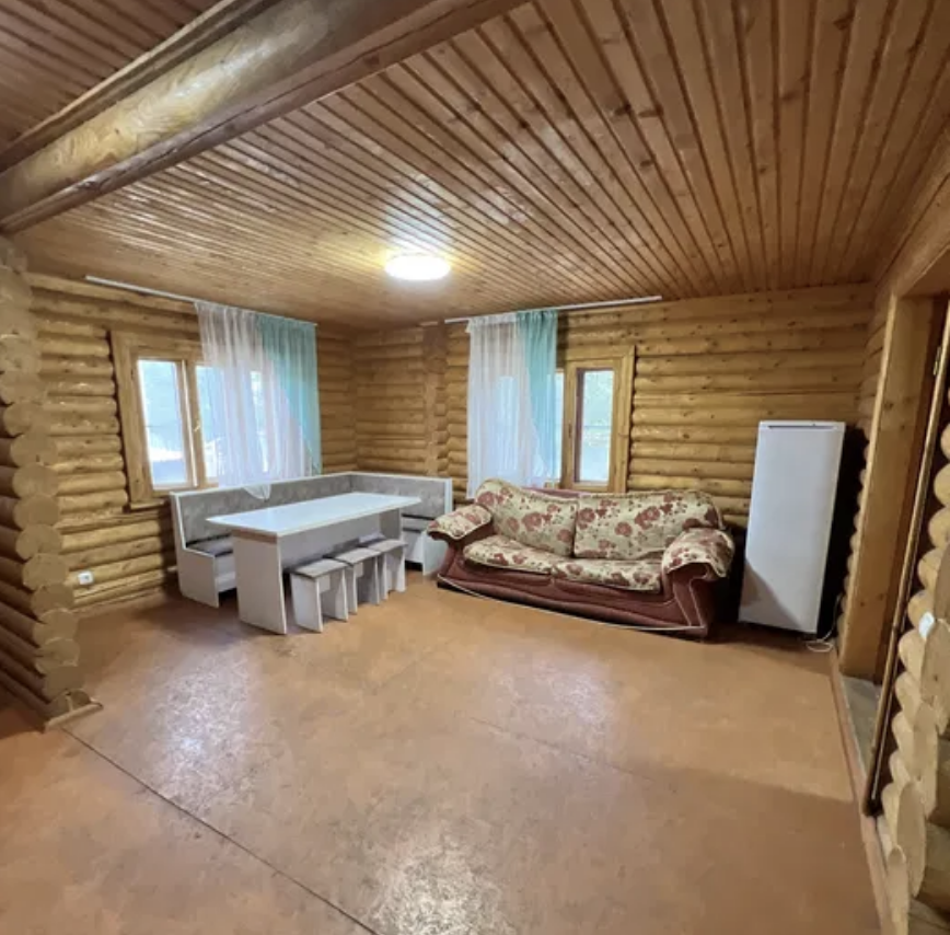 Ағаш үйдің интерьері, ас үстелі мен диванмен