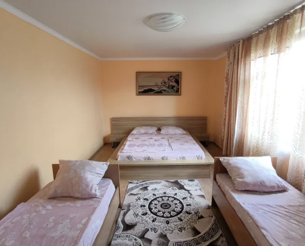 екі төсек пен күн сәулесі бар жатын бөлме