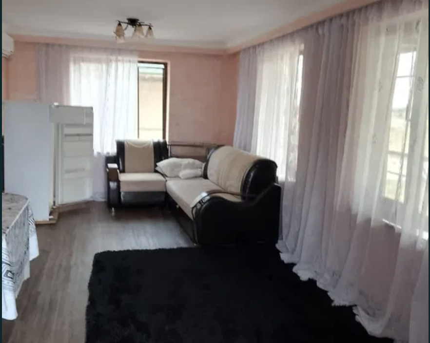 Гостиная с диваном и светлыми шторами