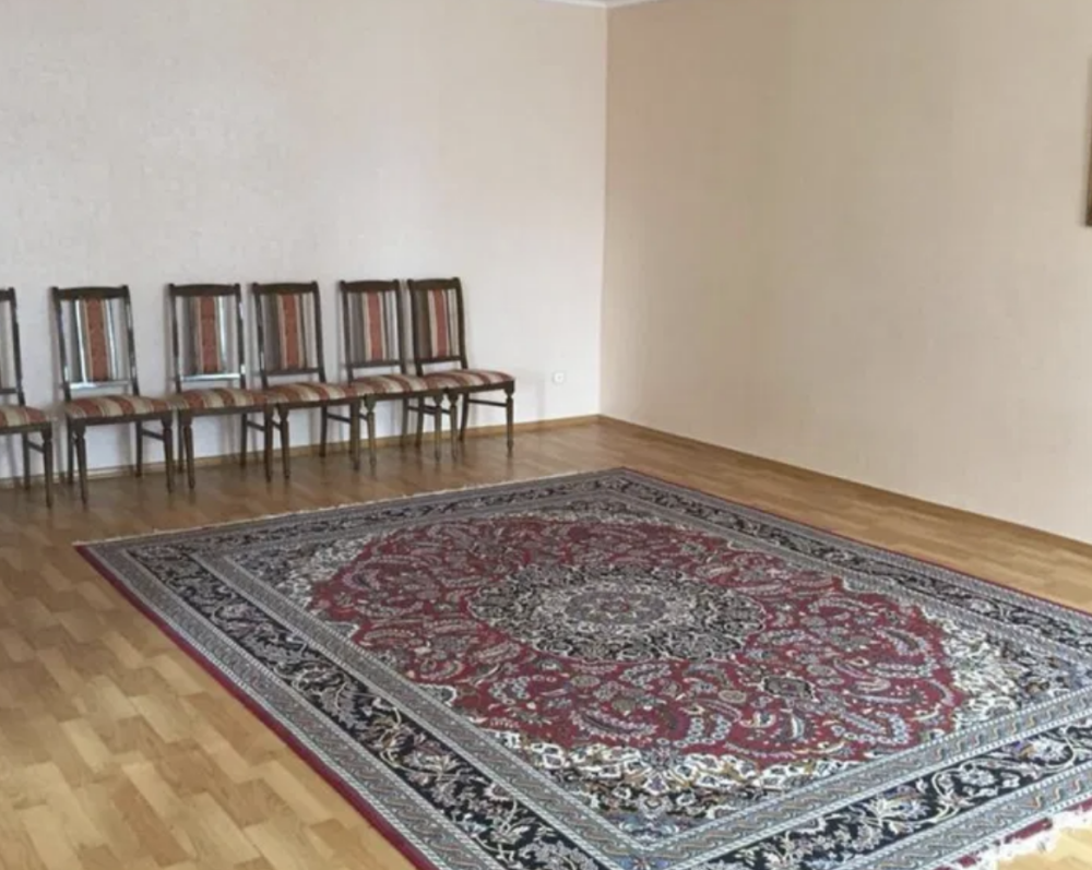 Ковры бар кең бөлме және қабырға бойында бос орындықтар