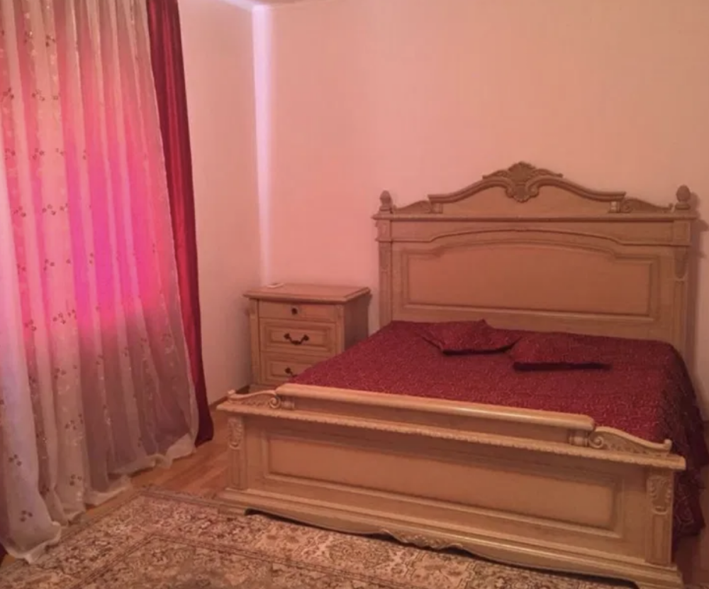 Төсек пен жарық перделерімен жатын бөлме