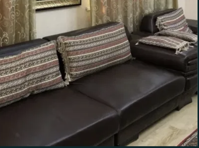 Декоративті жастықтармен қара диван