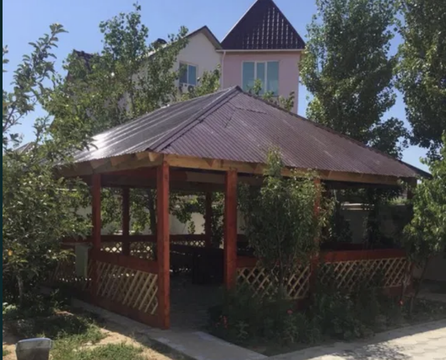 Крыша барлығы бар беседка және айналадағы жасыл ағаштар