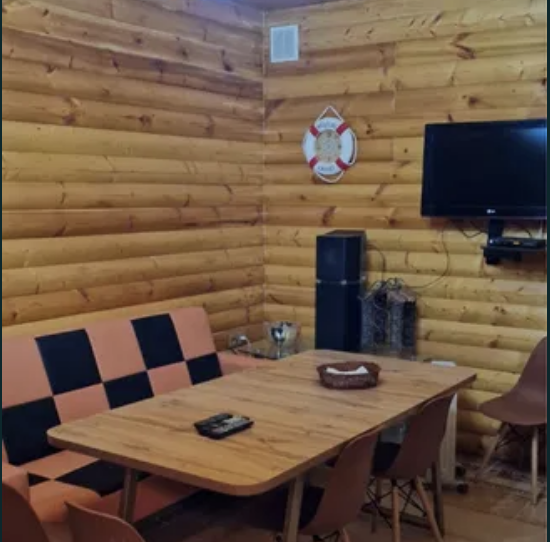 Внутренняя гостиная с деревянной отделкой и телевизором