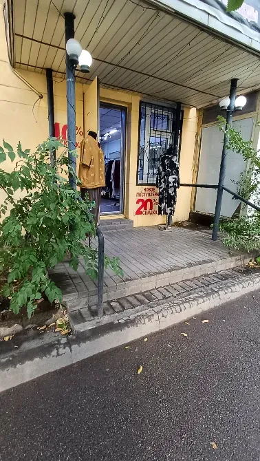 Көшеде витриналары бар киім дүкеніне кіреберіс