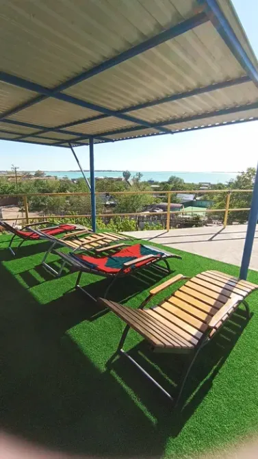 Открытая терраса с шезлонгами и зелёным газоном