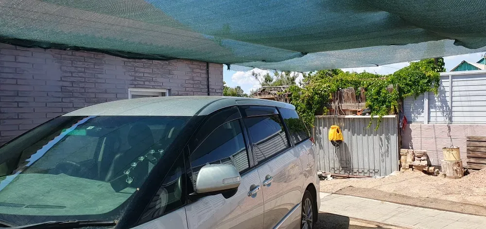 Автомобиль под навесом с защитной сеткой