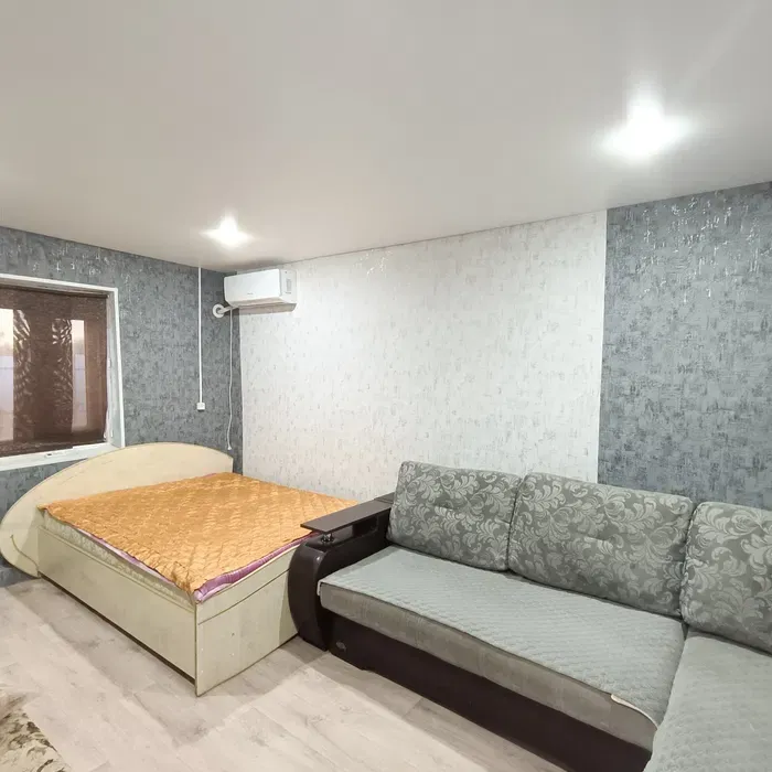 Комната с кроватью и диваном, оформленная в современных тонах