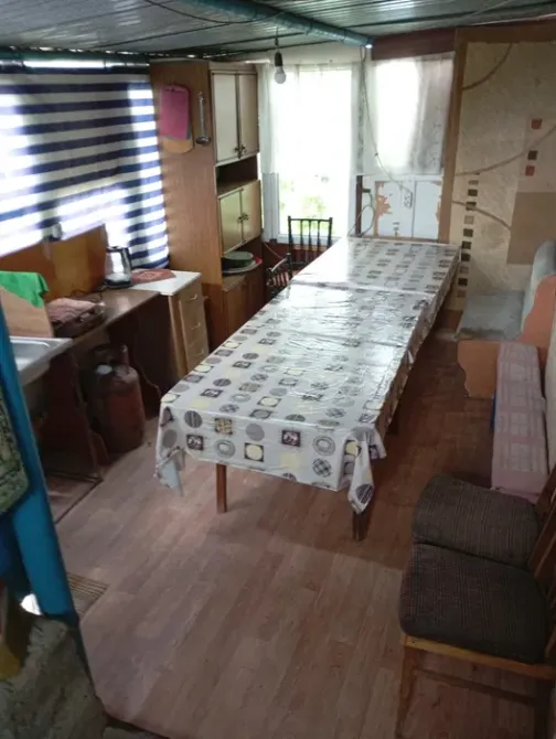 Үлкен үстел мен орындықтары бар ортақ асхана