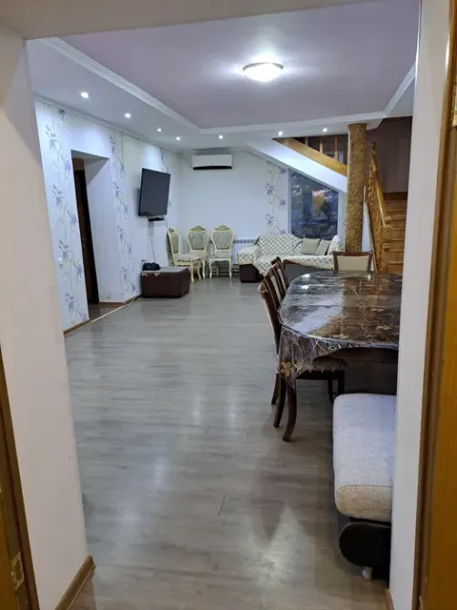 Вид на зал с обеденным столом и телевизором