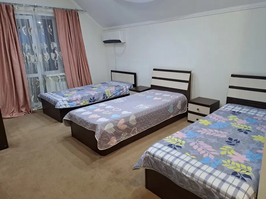 Комната с тремя кроватями, украшенная яркими покрывалами