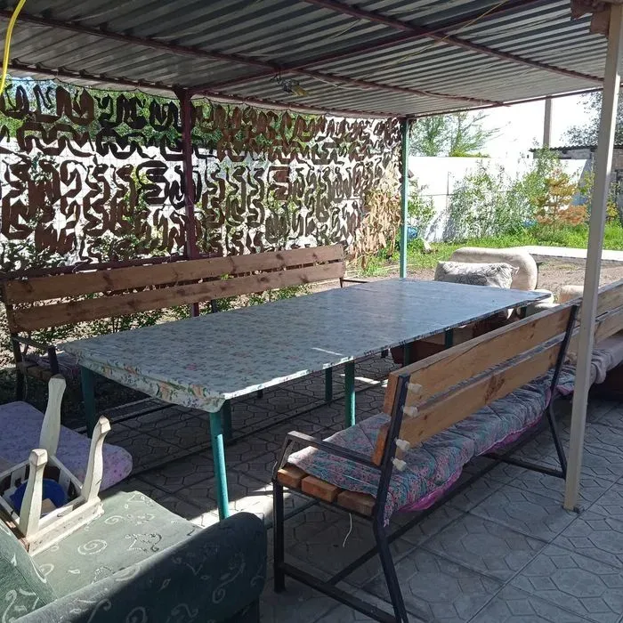 Зона для отдыха на улице с длинным столом и скамейками