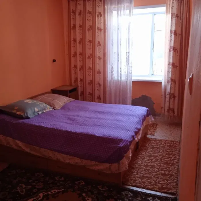 Уютная спальня с двуспальной кроватью и яркими шторами