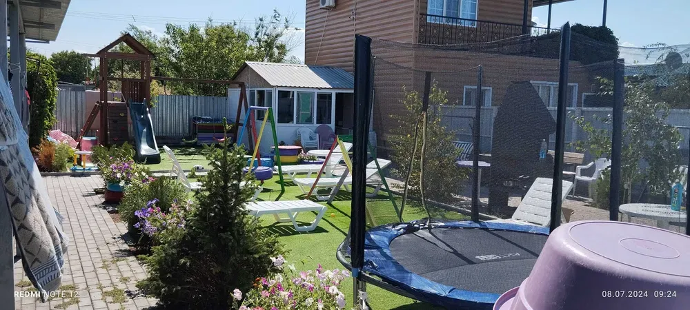 Двор с игровой площадкой, шезлонгами и батутом