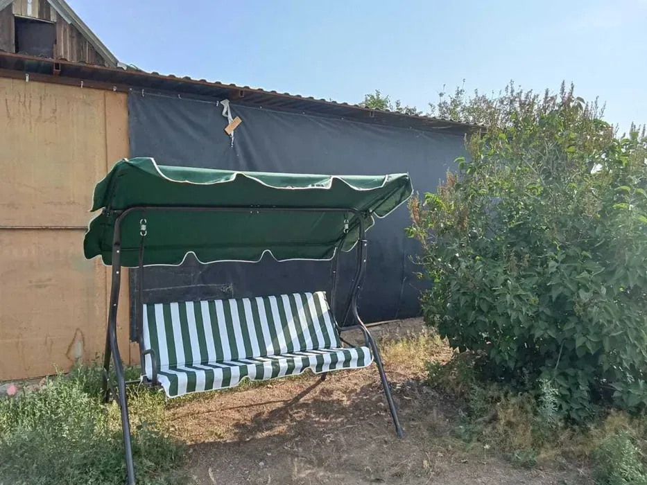 Качели на свежем воздухе, окруженные зеленью