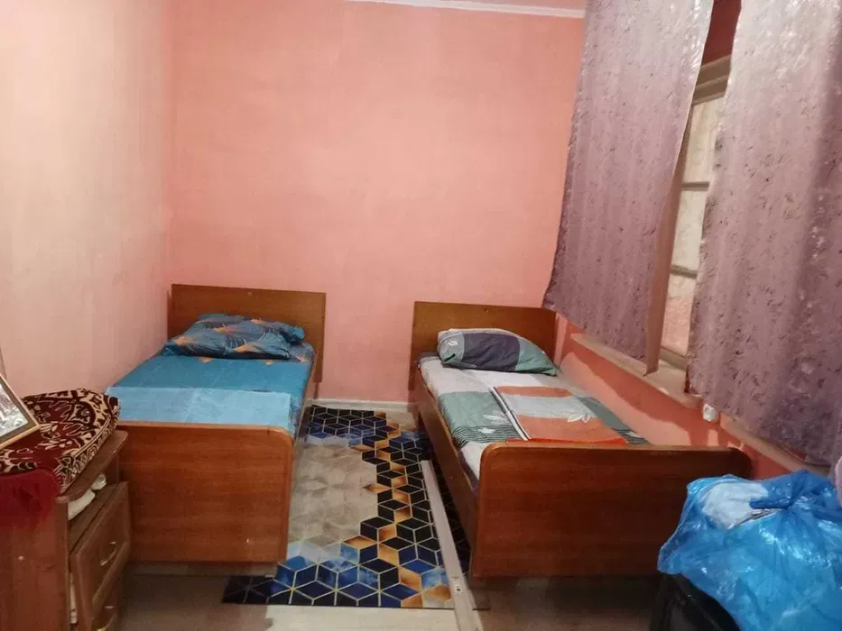 Комната с двумя кроватями и оранжевыми стенами