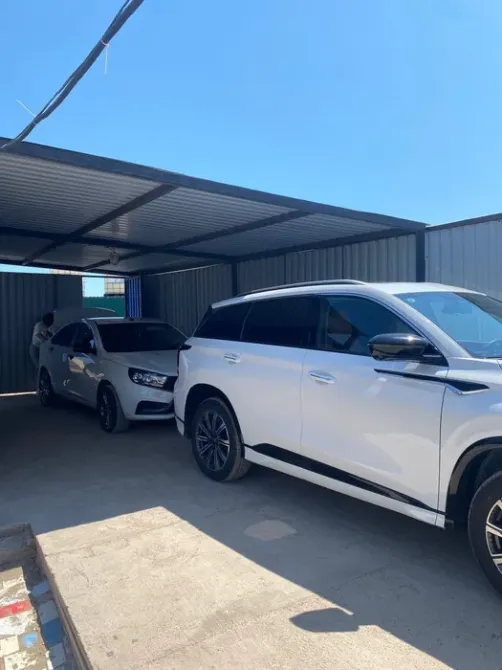 Ақ автомобильдер жабық гаражда ашық аспан астында