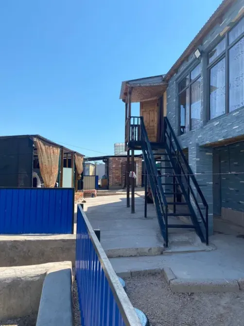 Ғимаратқа көтерілетін баспалдақ және жасыл өсімдіктер