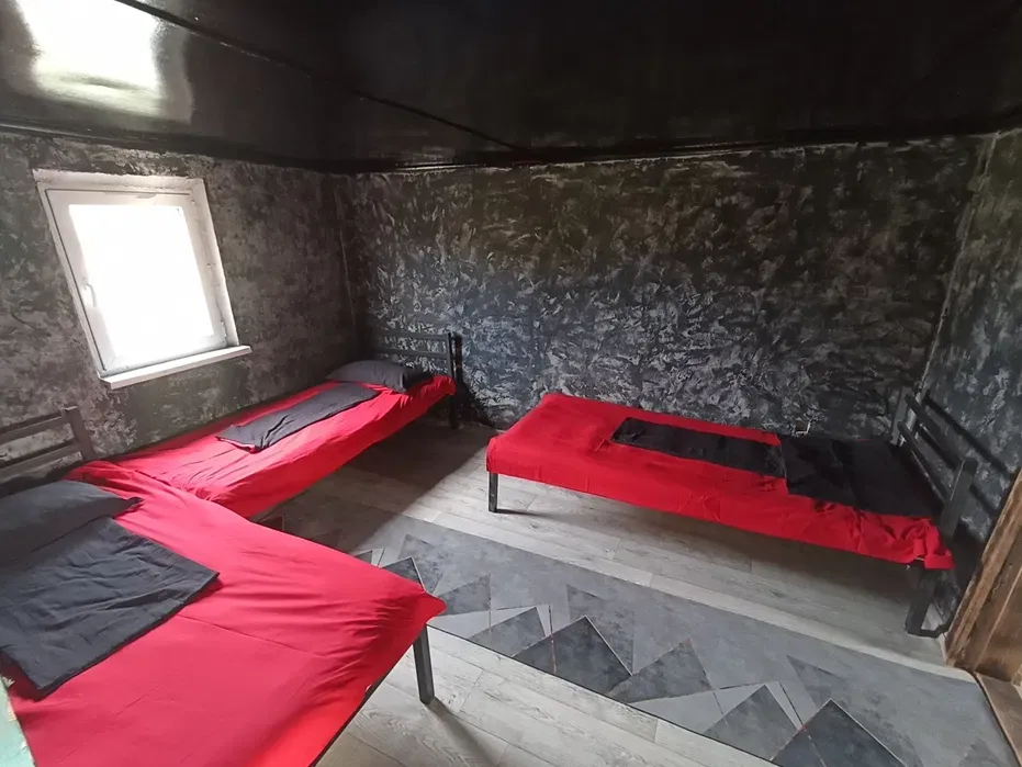 Спальная комната с тремя кроватями красного цвета