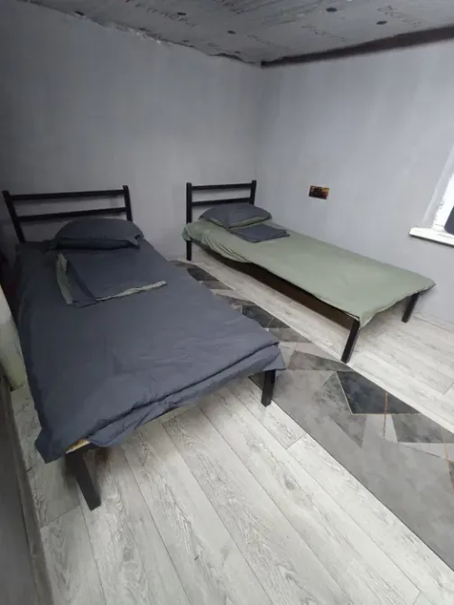 Спальная комната с двумя кроватями и серым постельным бельем