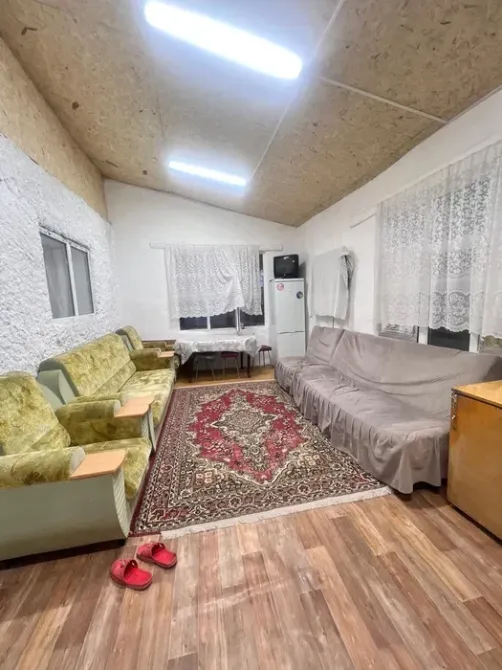 Пәтердің жұмсақ жиһаздары мен асүйі бар қонақ бөлмесі