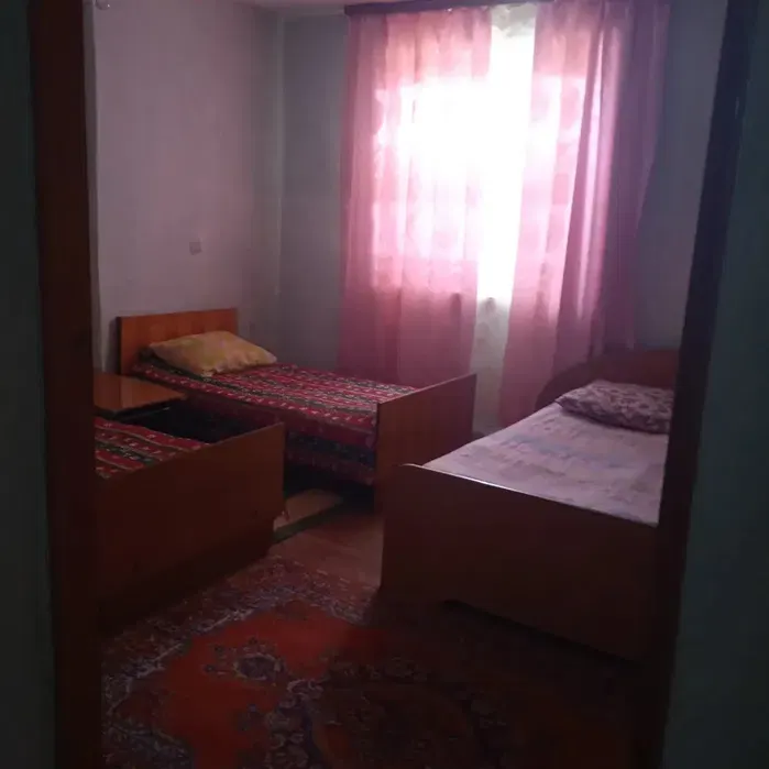 спальня с двумя кроватями и окнами с занавесками