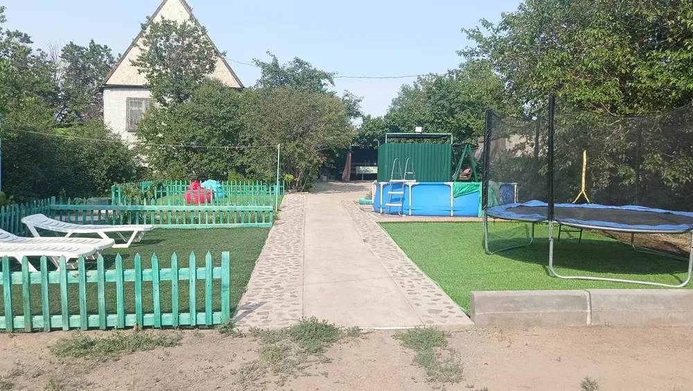 Двор с зелеными насаждениями, ограждением и бассейном