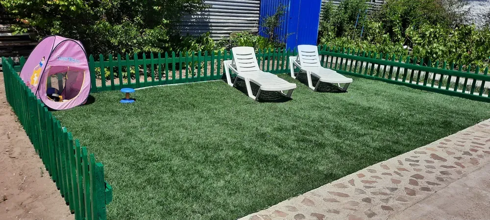 Зеленый уголок с шезлонгами и палаткой