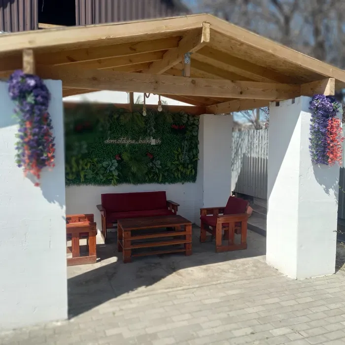 Уютты демалыс орны бар ыңғайлы альтанка гүлдермен және демалу үшін жиһазбен