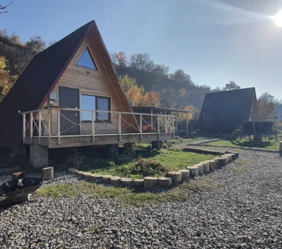 Ормандағы террасасы мен күн сәулесімен жабдықталған үй