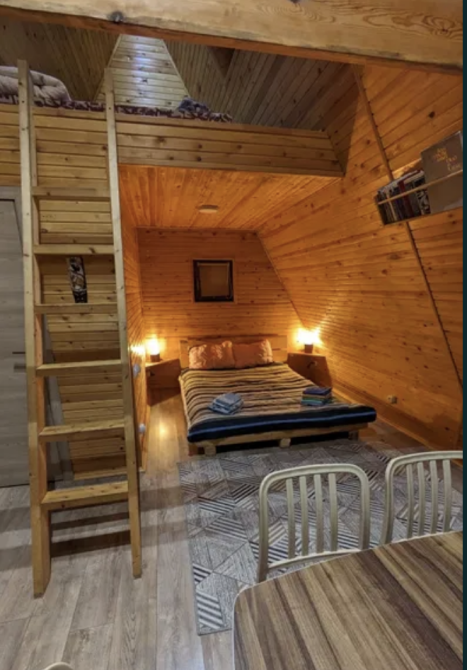 Екі адамдық төсегі мен екінші қабатқа апаратын баспалдағы бар жатын бөлме