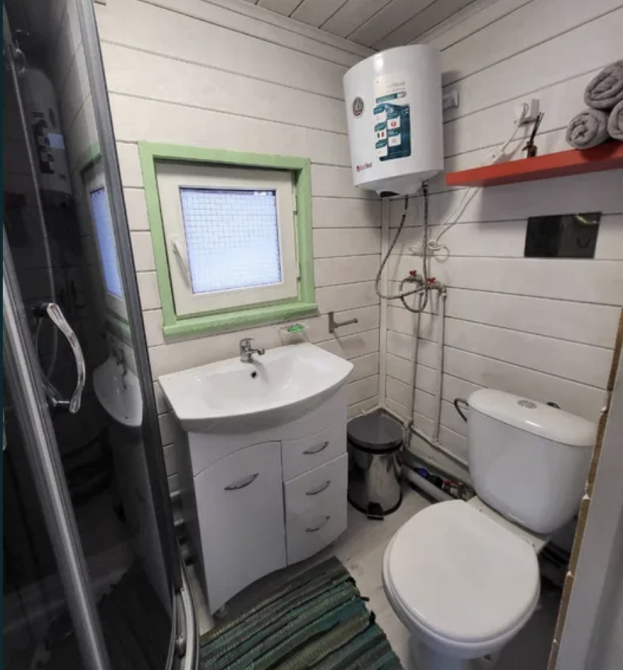 Ванная комната небольшого дома с душевой кабиной и сантехникой