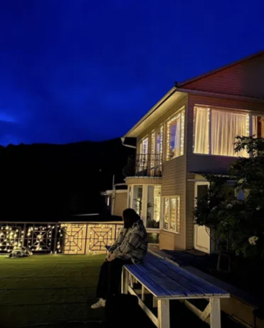 Түнгі көрініс, үйдегі оттар мен орындықтағы адам