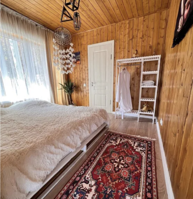 Ағаштан жасалған қабырғалары мен кілемі бар жатын бөлме