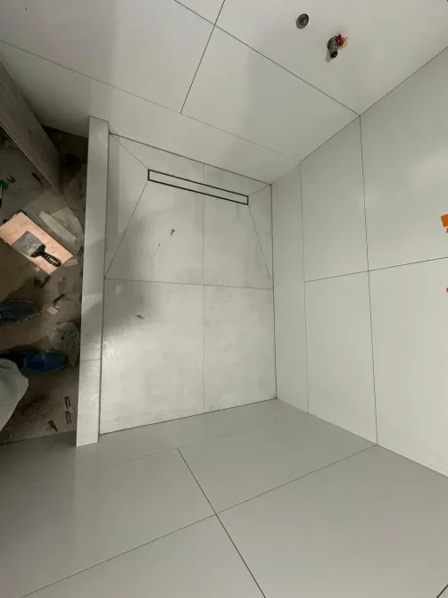 Заманауи душтық бұрыш ақ плиткалармен және жасырулы дренажбен