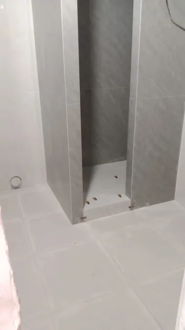 Душ кабинеті сұр қабырғалармен және таза ақ плиткамен