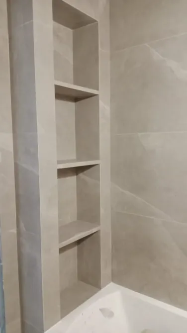 Ваннадағы сақтау сөресі сұр қабырғалармен және ваннамен