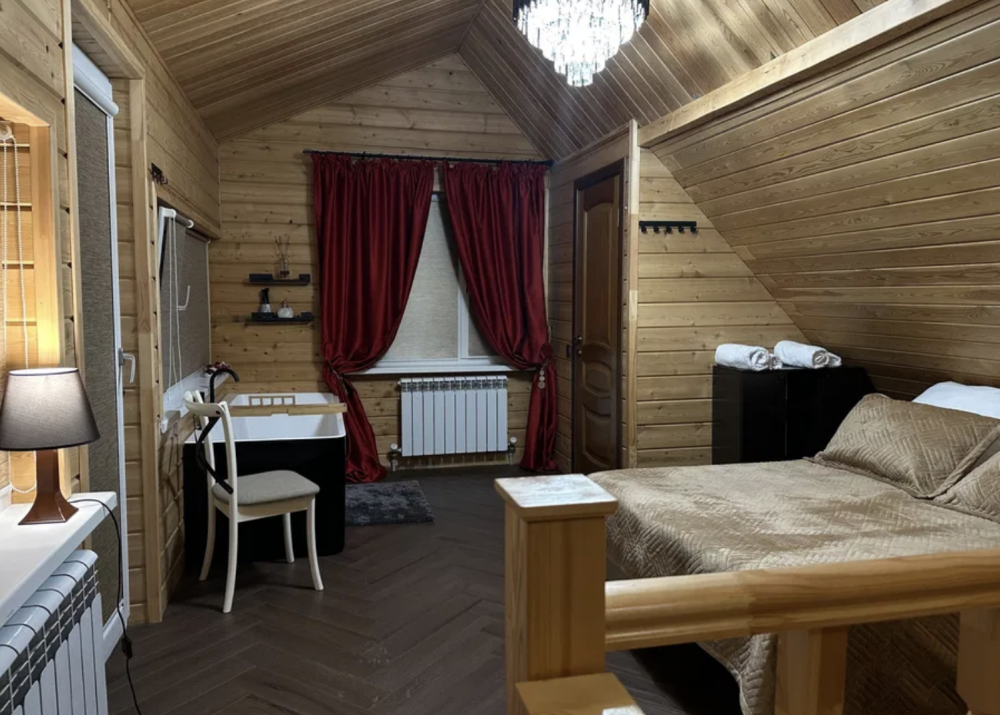 Ағаш қабырғалары мен элегантты жарықтандыруы бар жатын бөлме