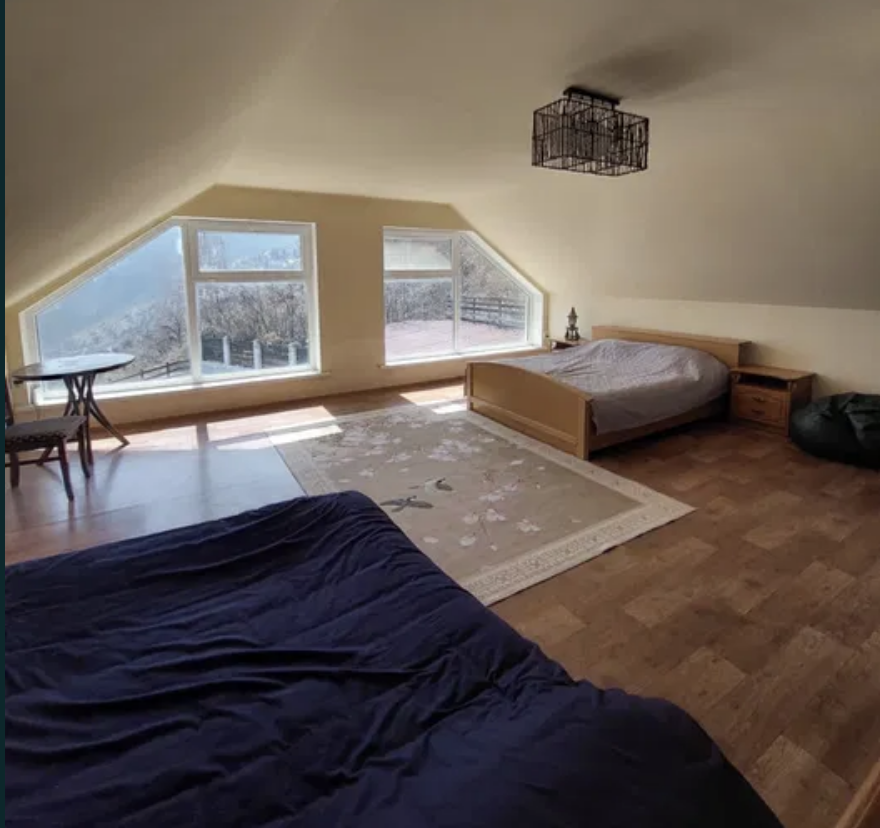 Спальня с двумя кроватями и окнами, выходящими на природу