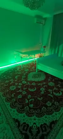 Зеленый свет в комнате с ковром и мебелью