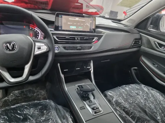 Красивый новый автомобиль с большим красным бантом, установленный в салоне с воздушными шарами