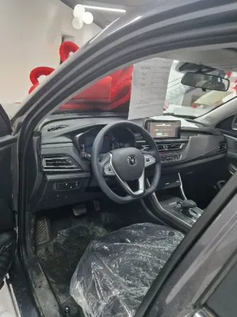 Красивый новый автомобиль с большим красным бантом, установленный в салоне с воздушными шарами